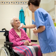 Caregiver providing respectful personal care assistance to a senior