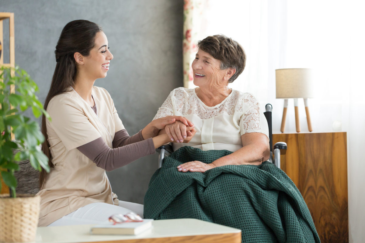 Caregiver assisting with light housekeeping tasks for a senior